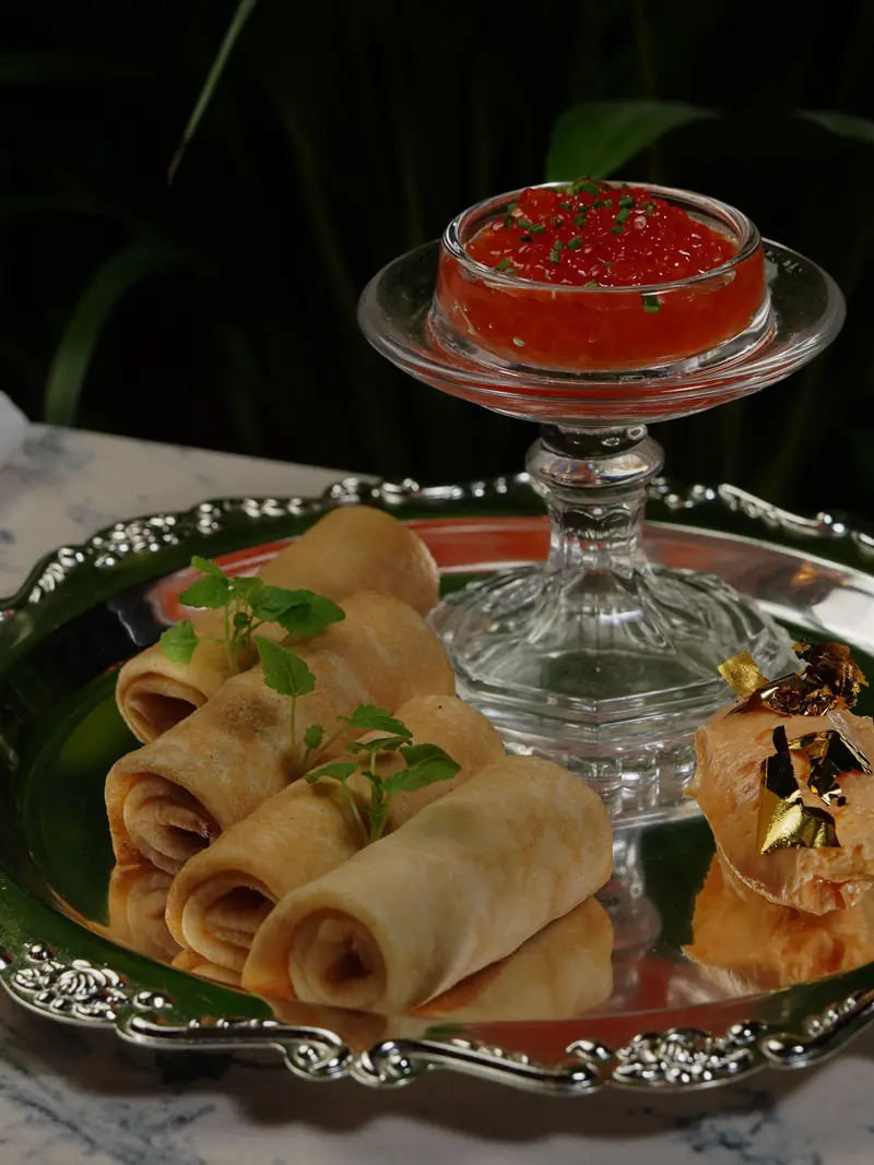An elegant platter with crepes, salmon roe and gold leaf